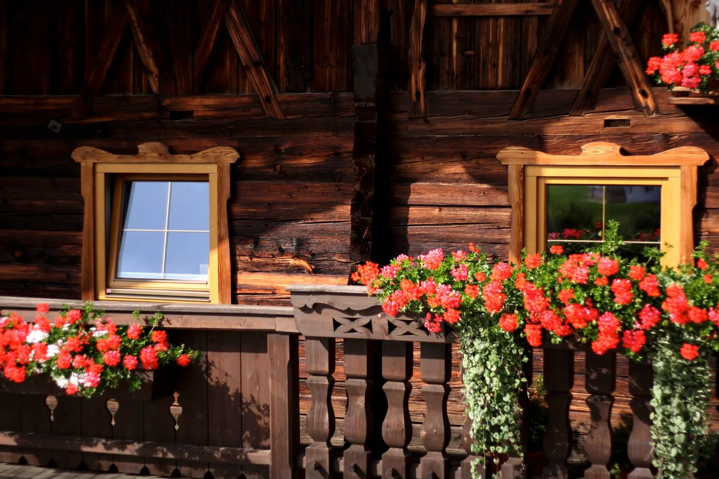 Holzfassade mit Blumenschmuck am Sennhof